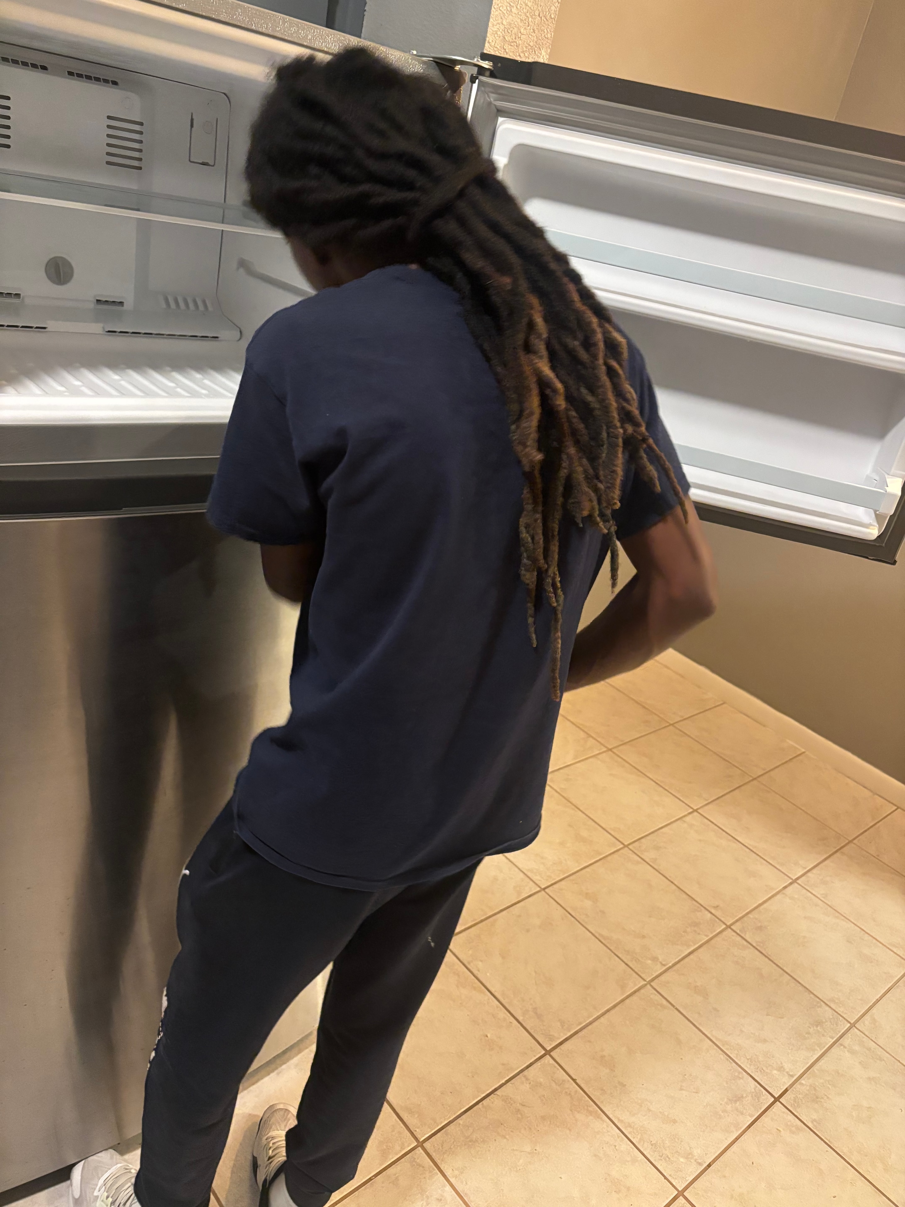 NorthStar team member cleaning refrigerator