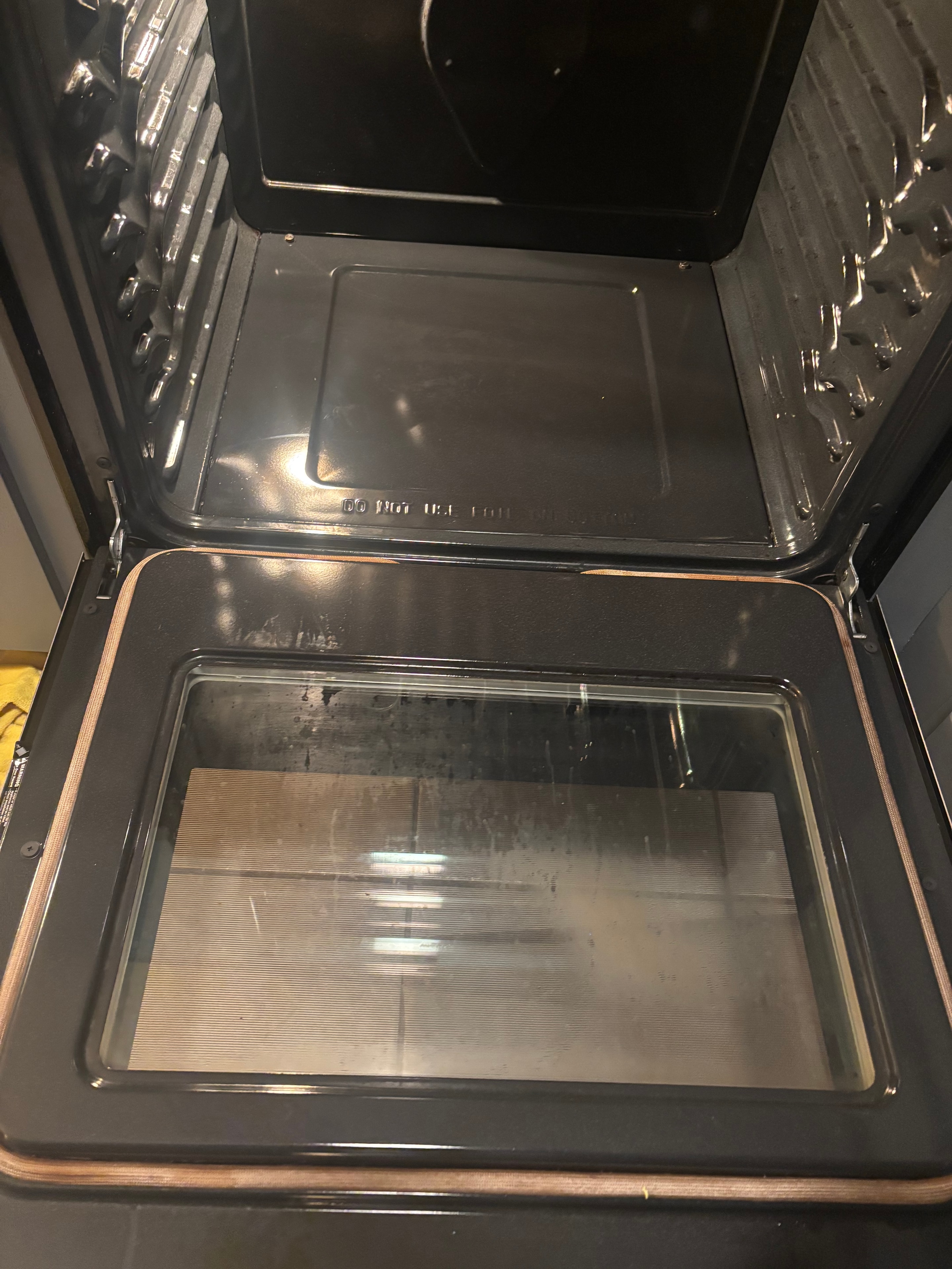Oven floor with thick black carbon buildup before cleaning
